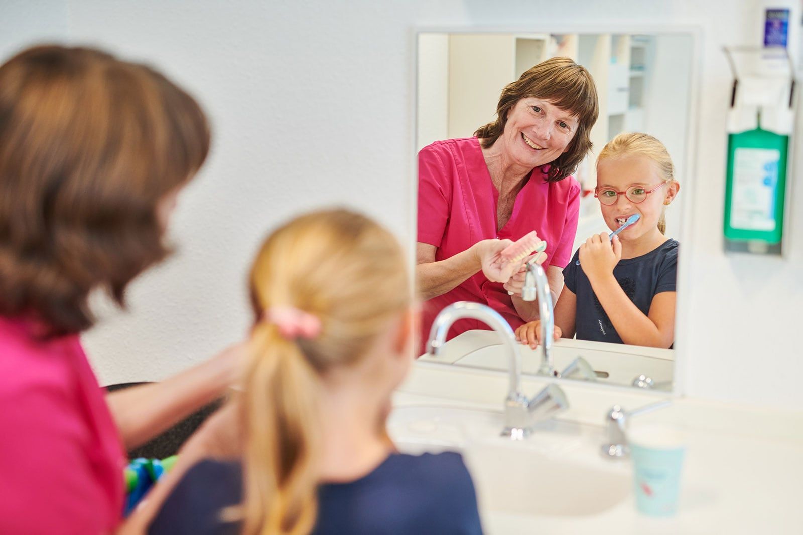 Prophylaxe Andrea Stock klärt junge Patientin über Zahnpflege auf